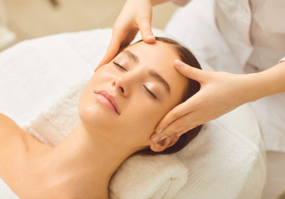 Face massage close up. Beautiful girl has a facial massage in a beauty clinic.